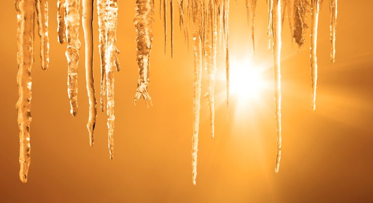 Hängende Eiszapfen werden von Sonnenstrahlen beleuchtet