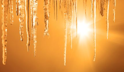 Hängende Eiszapfen werden von Sonnenstrahlen beleuchtet