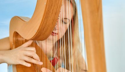 Frau die eine Harfe spielt