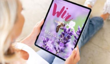 Frau schaut auf ein Tablet - das Cover zeigt eine Biene auf Lavendelblüten