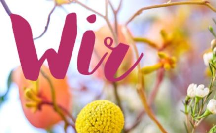 Titelfoto Wir Nr. 74 - mit bunten Frühlingsblumen im Hintergrund