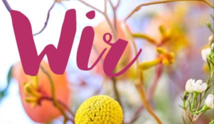 Titelfoto Wir Nr. 74 - mit bunten Frühlingsblumen im Hintergrund